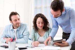 Two interns working together assisted by their course supervisor