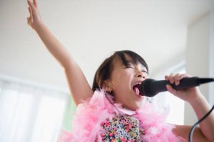 Petite fille déguisée en train de chanter dans un micro