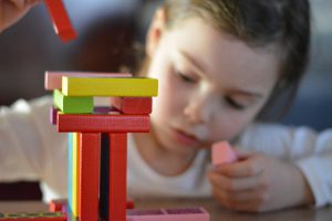 petite fille qui joue avec des cubes de construction