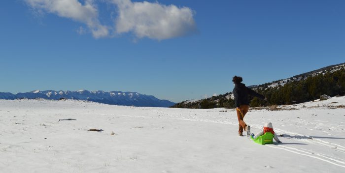 Une femme qui tire un enfant sur une luge à la montagne