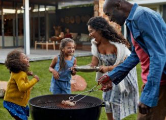 famille de deux adultes et deux enfants autour du barbecue