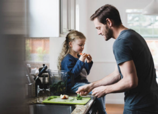 un papa et sa fille dans la cuisine qui préparent le repas